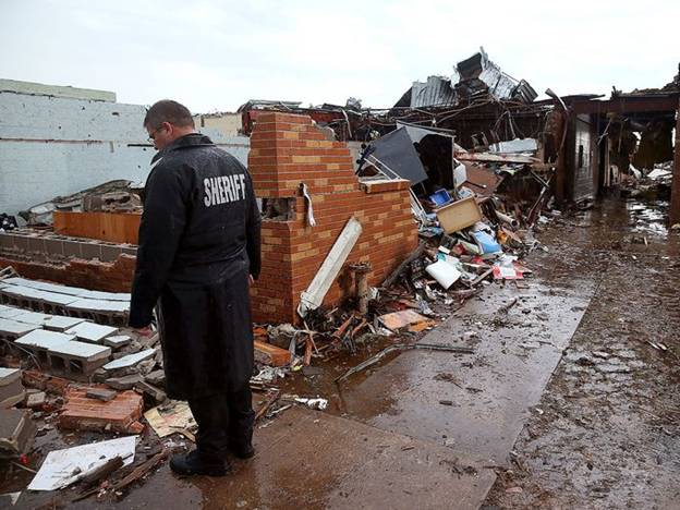 A sheriff's deputy stands in the wreckage of the Plaza Towers Elementary School.
