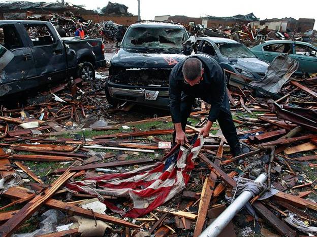 Mark Hamm, a deputy sheriff and Moore City councilman, retrieves the American flag at Towers Plaza Elementary School in Moore, Okla. The school was destroyed by a massive tornado May 20.